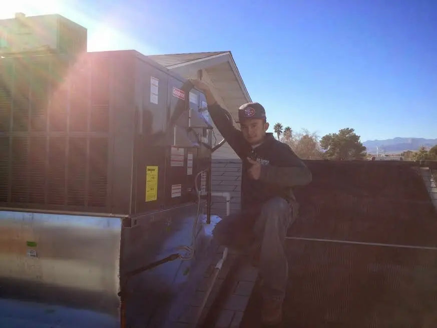 HVAC technician performing HVAC Inspection on a rooftop unit in Thousand Palms